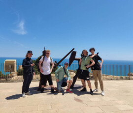 Uczniowie pozują na tarasie widokowym z morzem w tle podczas wycieczki do Alicante.