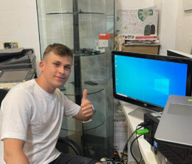 Uczeń siedzi przy laptopie i monitorze podczas praktyk zawodowych w Walencji.