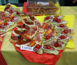 Talerzyki z przekąskami opisanymi jako tapas na stoisku poświęconym Hiszpanii.