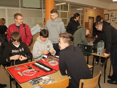 Kandydaci i uczniowie rozmawiają przy stoisku podczas I Dnia Otwartego ZSŁ.